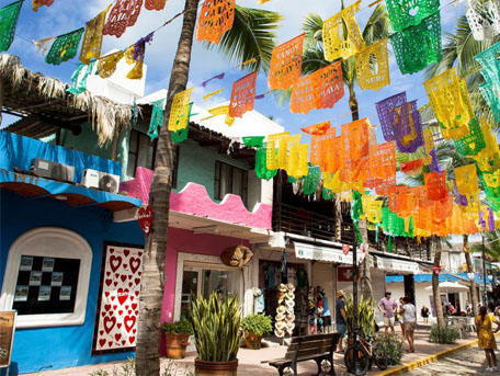 Picture of a mexican town with various colored flags